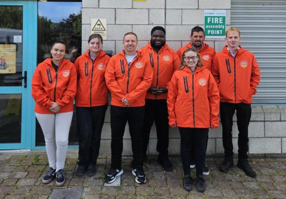 Enable Ireland's Face-to-Face fundraising team standing together outside the Enable Ireland Headquarters in orange Enable Ireland jackets
